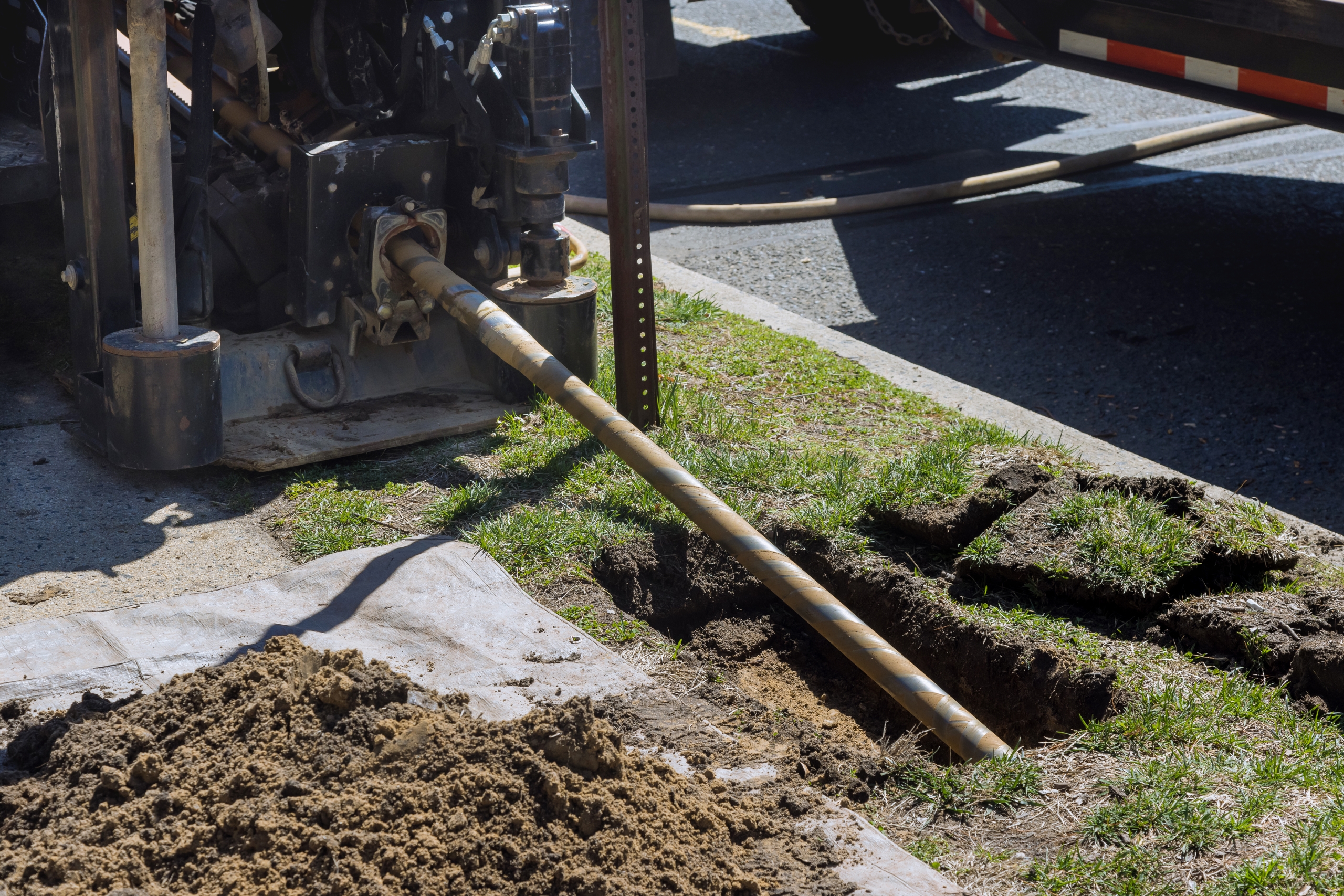 Low angle view of trenchless laying of communications, pipes and water pipes with horizontal directional drilling technology machine work process